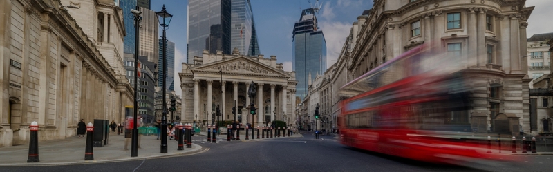 Image shows London bus moving with Royal Bank of England in background