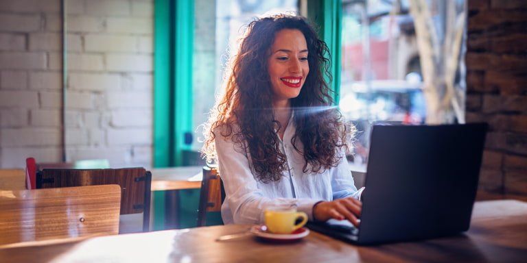 Personal investment account image of a person on a laptop in a coffee shop