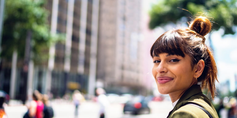 Investment image of a smiling person on a busy city street